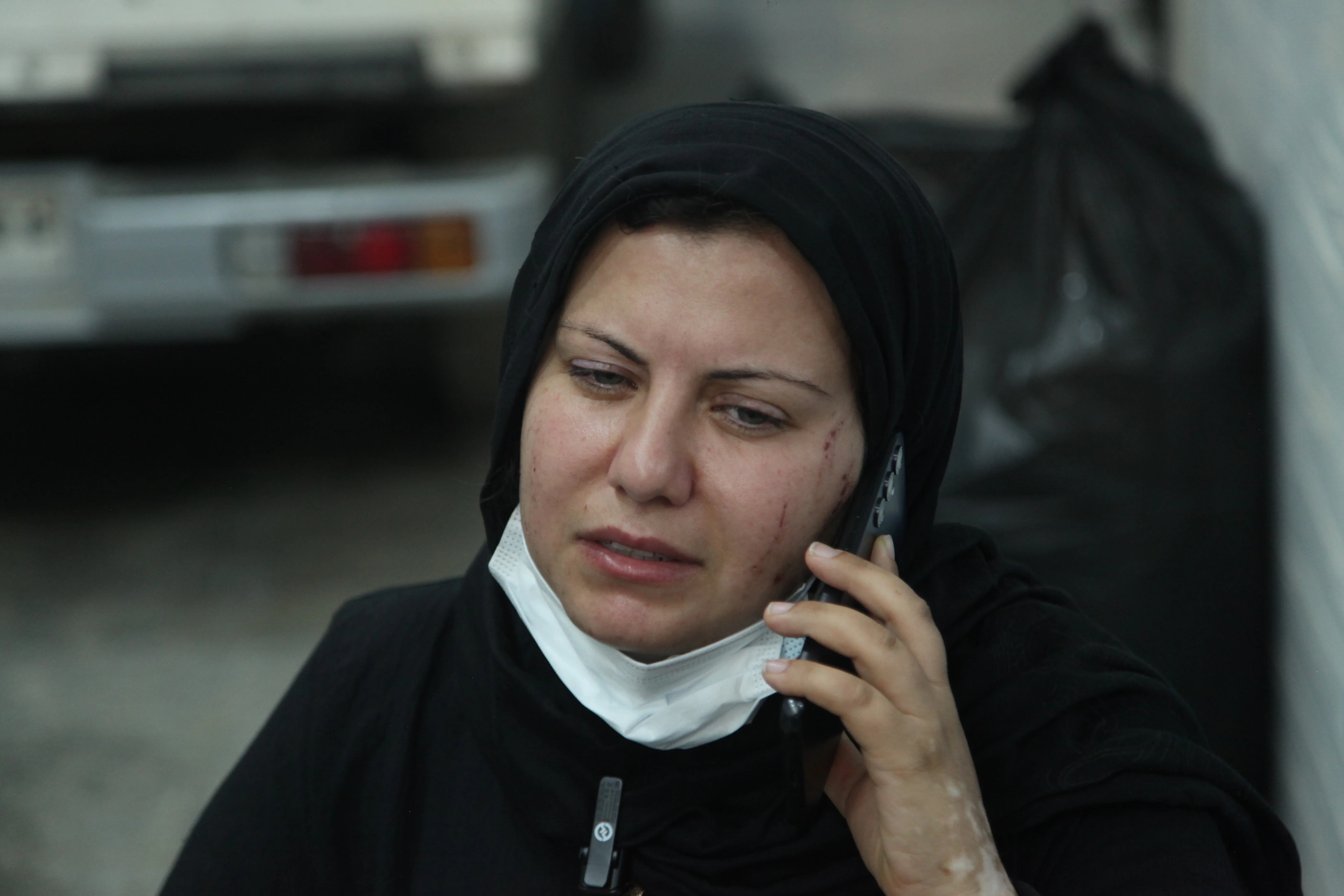A mother, at the wall of the school.